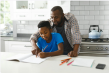 Father and Son Doing Homework in Kitchen 