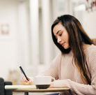 Student sitting at a desk writing 