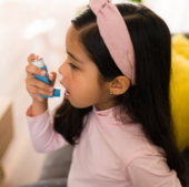 Young girl using an asthma inhaler