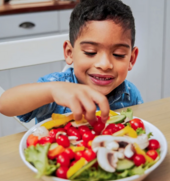 Young boy eating a salad