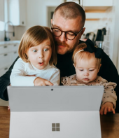 Dad with two daughters looking at a computer