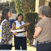 Surveyors in vests interviewing a South Bay resident
