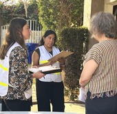 Surveyors in vests interviewing a South Bay resident