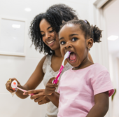 Mother and daughter brushing their teeth
