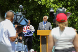 William B. Gould IV at podium in front of crowd and TV cameras	