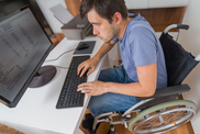 Man in wheelchair using a computer