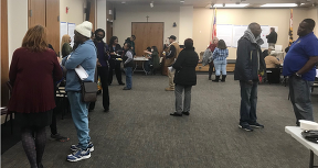 Group of people standing and talking at a community meeting