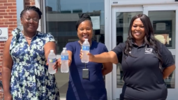 Staff at Weinberg Housing & Resource Center hold cold bottles of water