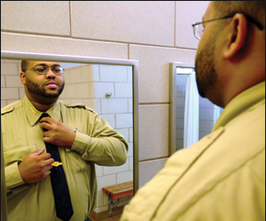 Photo of: Ranger adjusting uniform in mirror