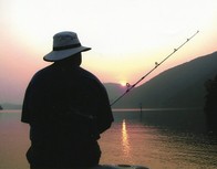 Picture of Man fishing on lake at sunset