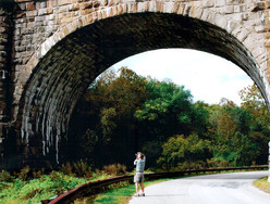 Photo of man taking photograph of bridge