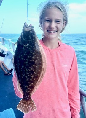 Photo of girl on a boat holding a flounder