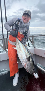 Photo of young man on a boat holding a large fish