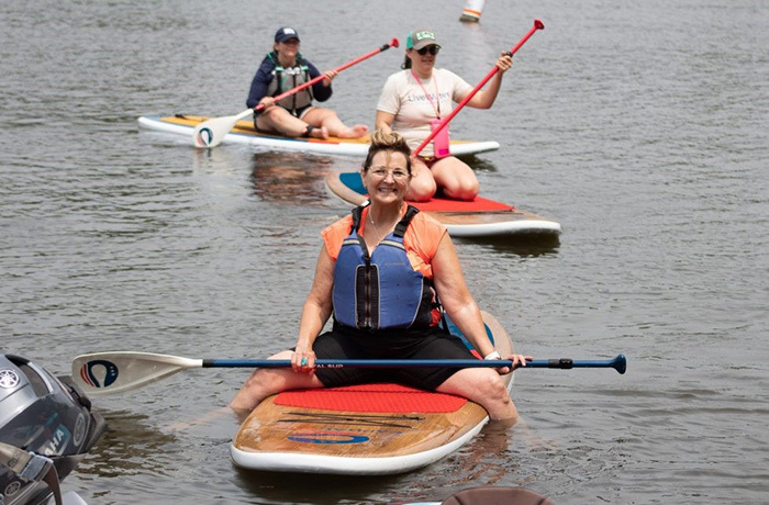 Three people paddling on paddleboards. 
