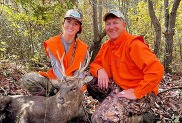 Man and woman hunters with a sika deer