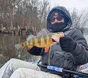 Woman in a kayak holding a yellow and black fish
