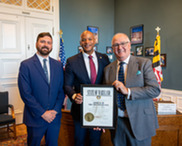 A man receiving a certificate in the governor's office