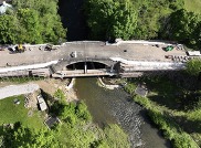 Drone image of large stone bridge with work crews