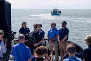 People standing on a boat for a news conference