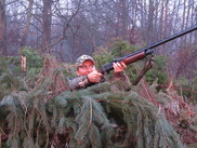 Woman hunter aiming a shotgun in the air