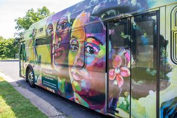 Photograph of the MTA's New Pride Bus featuring two painted individual headshots 