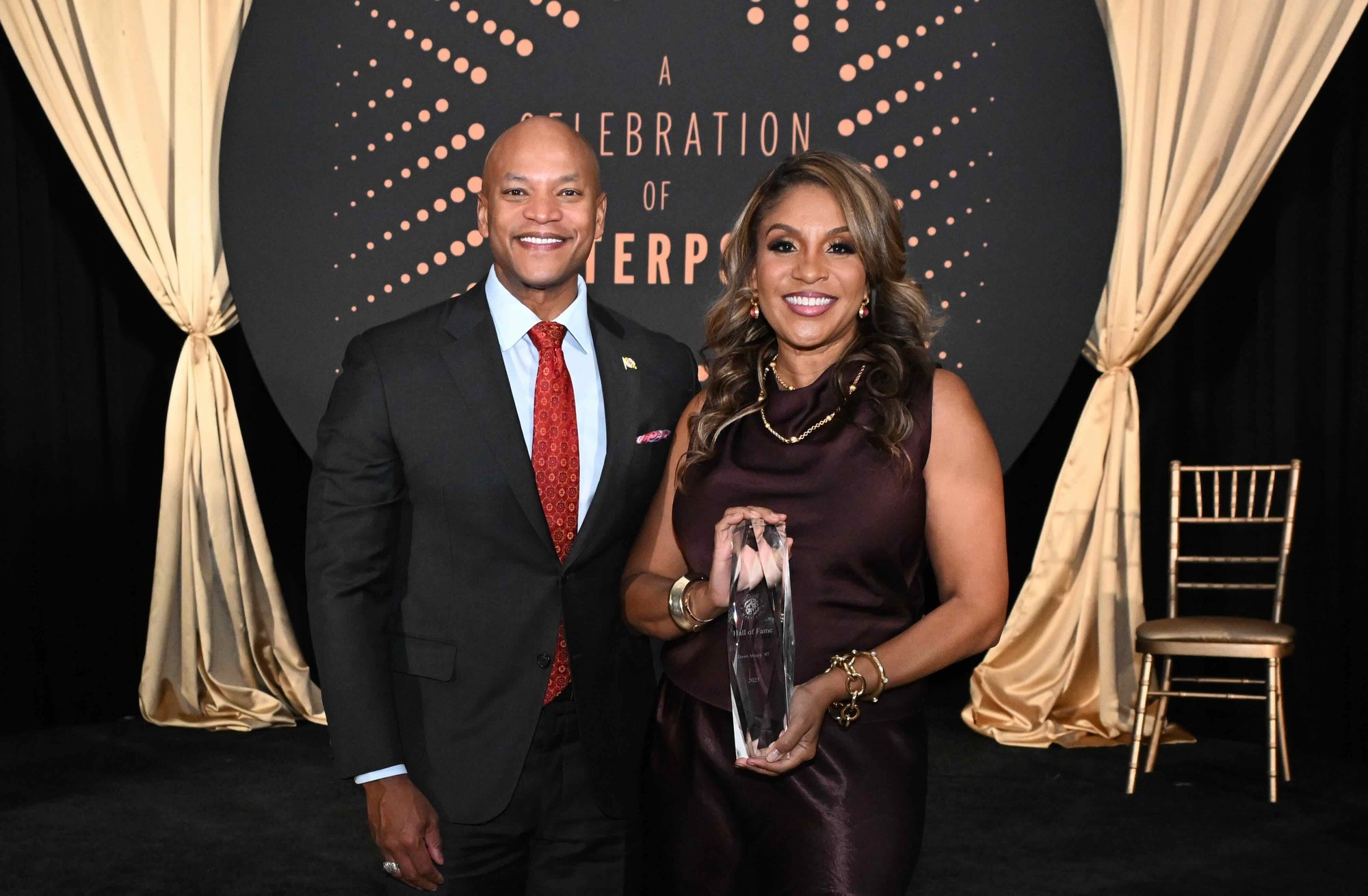 Governor Wes Moore and First Lady Dawn Moore smiling with award