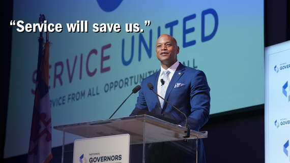Governor Moore on stage, with quote "Service Will Save Us"