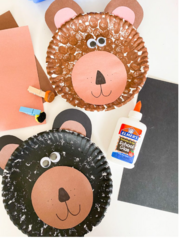 Image: Two paper plates painted as black and brown bears.  A bottle of glue, construction paper, and clothespins attached to pom poms surround faces.