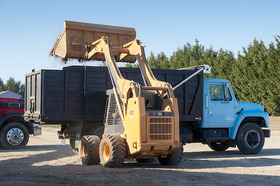 Chicken manure being transferred into a blue truck copyright Edwin Remsberg