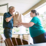 Photo of volunteer delivering food to older adult