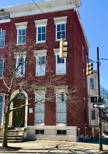 three story brick row house, downtown Baltimore, blue skies