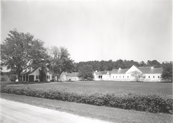 Black and white photograph of a historic Maryland farm complex featuring a main house, outbuildings, and a large barn.
