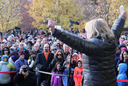 Nancy Floreen viewed from behind as she addresses the crowd and raises her arms in solidarity.