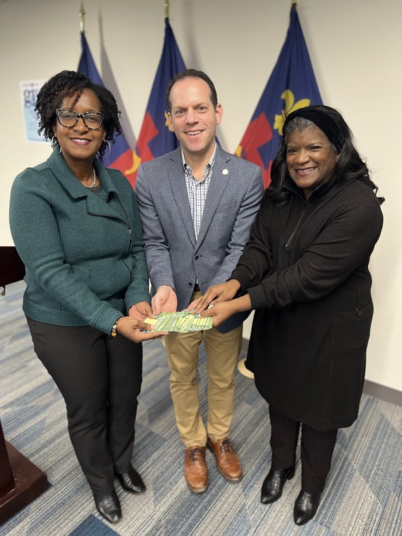 Council President Glass presents the donated Metro cards with two Head Start officials.