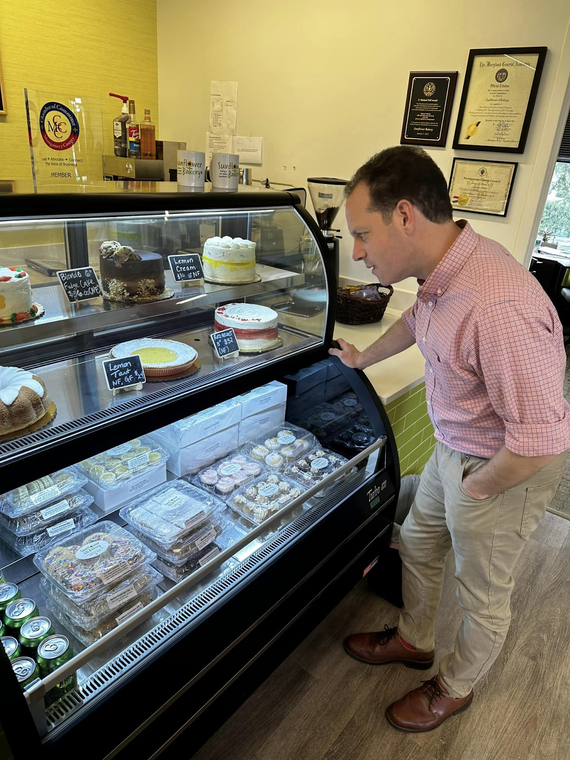 Council President Glass looks at a display case of baked goods at Sunflower Bakery.