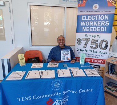 Dr. Gilberto Zelaya at a table with voter registration materials.