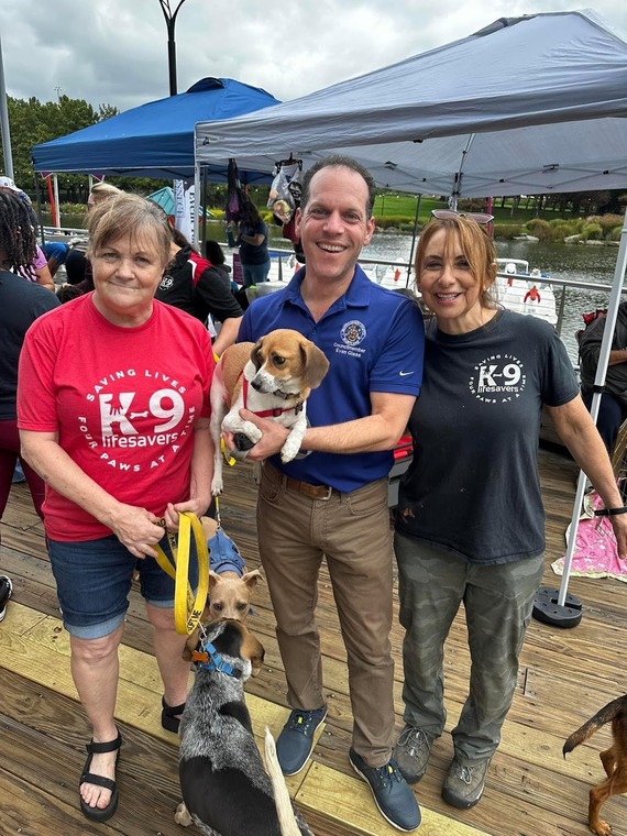 Council President Glass and Poppy pose with volunteers at Beltway Barks.