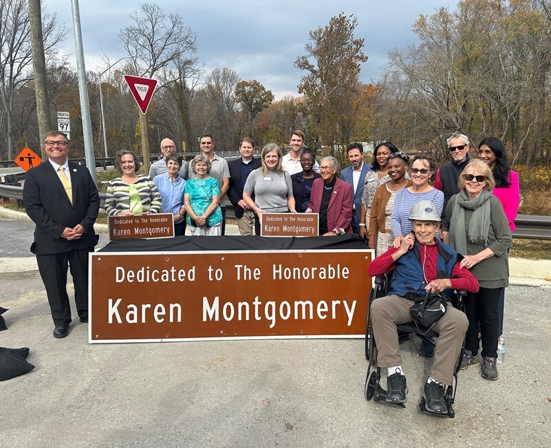 Group photo with a sign dedicated to The Honorable Karen Montgomery