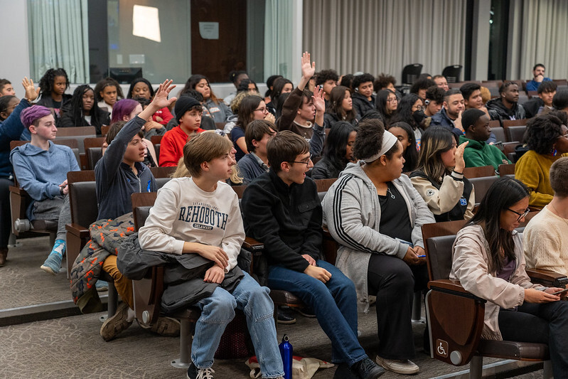 Students raise their hands to ask questions during the Youth Town Hall at the Council chamber.