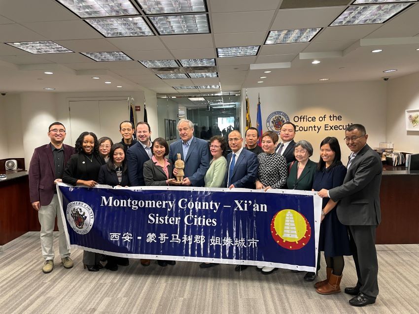 Leaders from Montgomery County and Xi’an pose in front of a Sister Cities banner in Rockville.