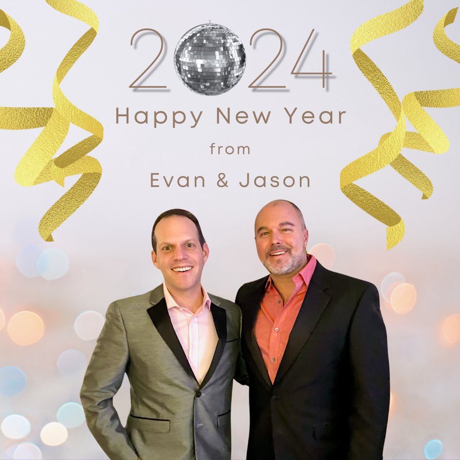 Jason and Evan standing in front of a banner that says "Happy New Year from Evan and Jason"