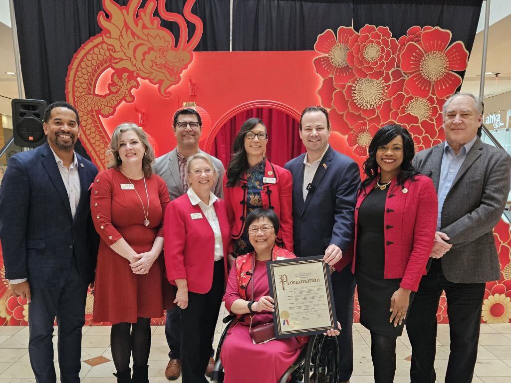Councilmembers and AAPI community leader pose in front of a Lunar New Year red dragon display.