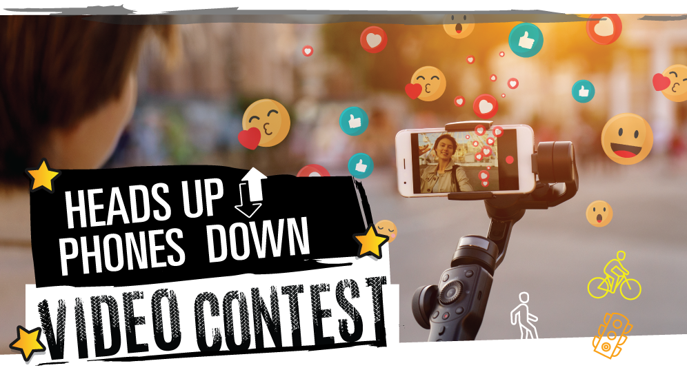 A graphic showing a person recording a video on their smartphone. The text reads "Heads Up Phones Down Video Contest." Emojis surround the image.