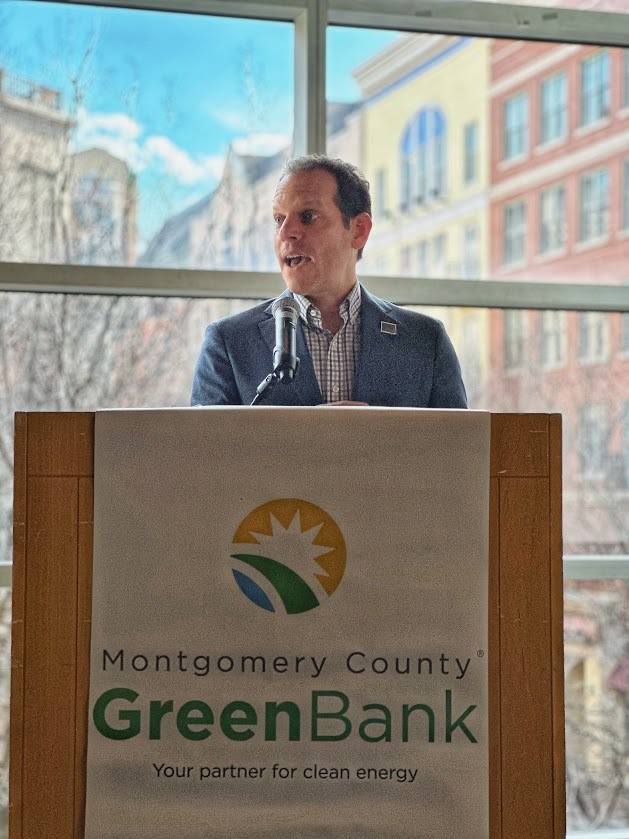 Councilmember Glass speaks at a lectern with the Montgomery County Green Bank logo on it