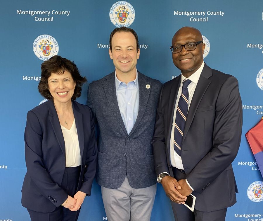 L to R: Outgoing Executive Director Ms. Michaelson, CP Friedson, and new Director Mr. West pose in front of Council backdrop.