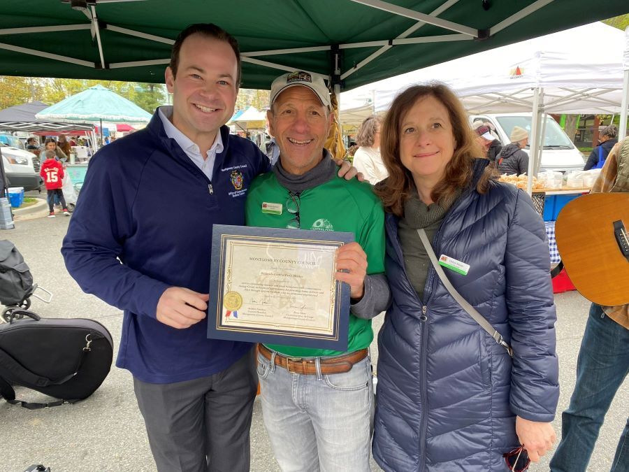 CP Friedson presents a Council certificate to Mitch and Debbie of the Bethesda Farmers Market.