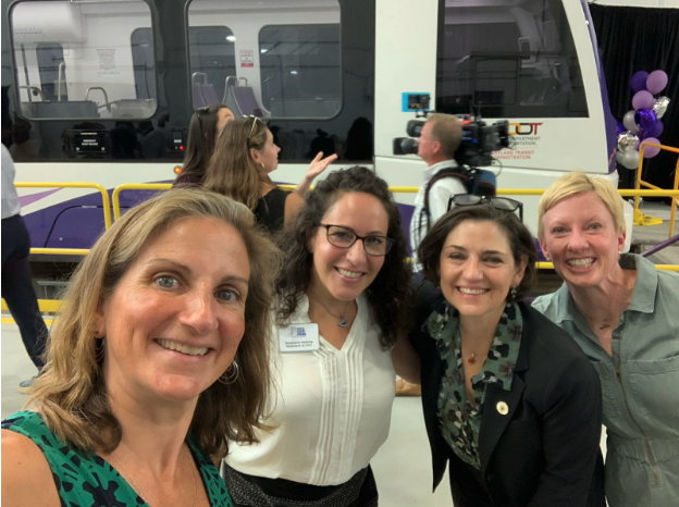 VP Stewart, Del. Charkoudian, and friends with the Purple Line vehicle in the background