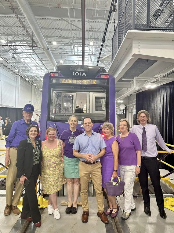 Councilmember Glass standing with residents in front of one of the new Purple Line Vehicles 