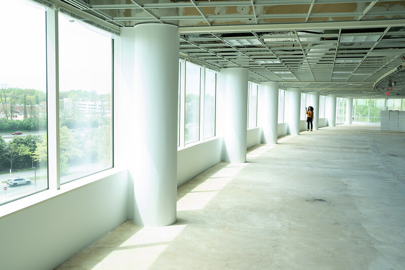 Inside view of an empty office building with a woman looking out the window.