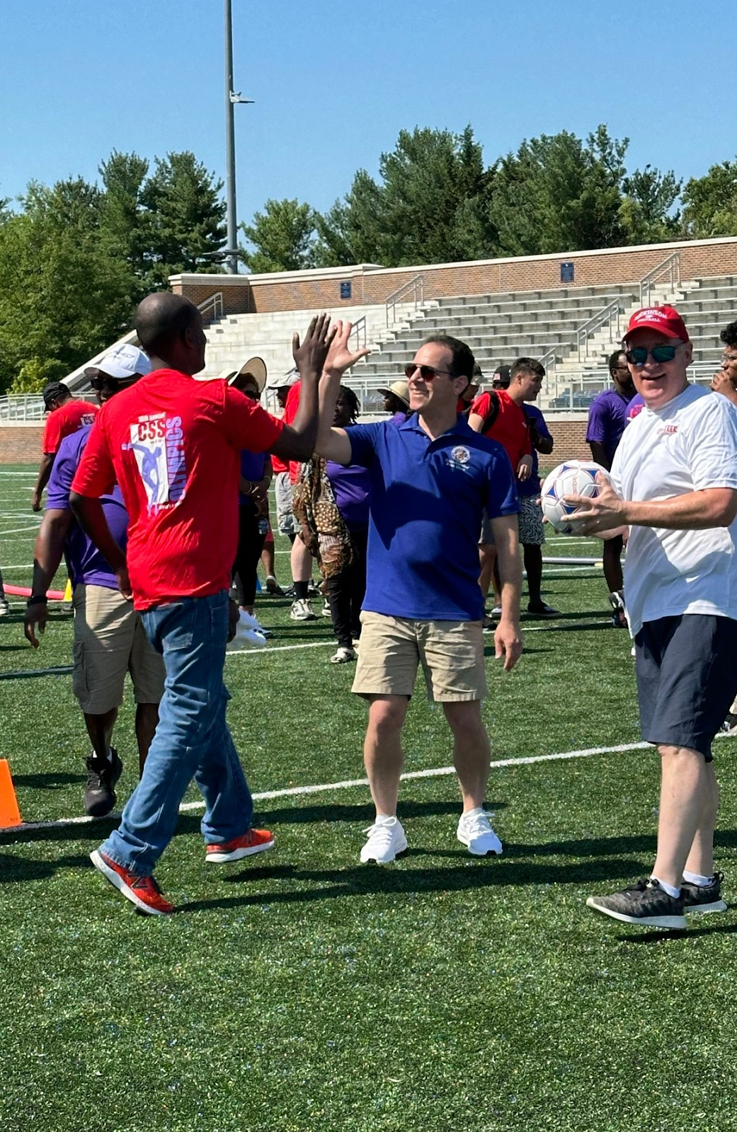 A photo of Councilmember Glass giving a high-five to a participant